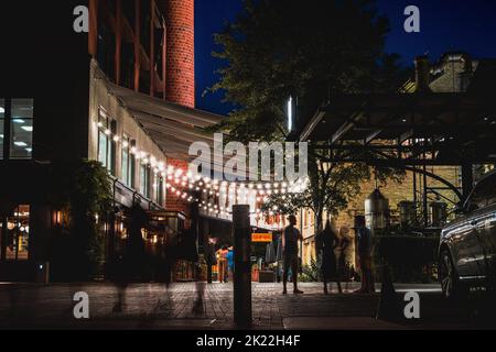 Un colpo sfocato di persone sulla strada di Pearl District a San Antonio, Texas durante la notte Foto Stock