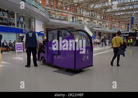 Un veicolo di assistenza passeggeri sull'atrio della stazione ferroviaria di Waterloo, Londra, Regno Unito Foto Stock