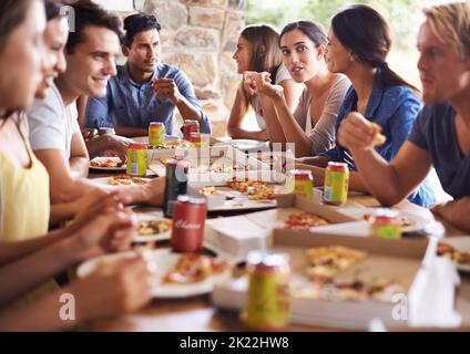 Theres pizza per tutti. Un gruppo di amici che gustano la pizza insieme. Foto Stock