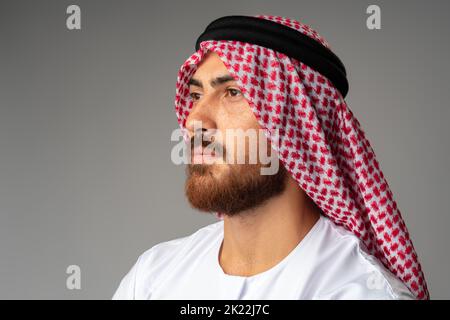 Ritratto del giovane arabo su sfondo grigio in studio Foto Stock