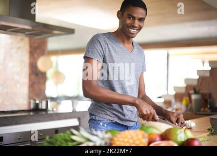 HES un tritatutto fine. Un bell'uomo etnico che prepara le verdure all'interno. Foto Stock