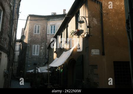 Un basso angolo di case tradizionali italiane che si affacciano sul cortile con la luce del sole che cade su di esse Foto Stock