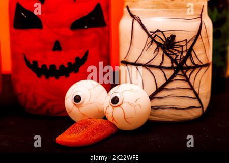 Halloween composizione di occhi, zucca e un vaso con un ragno Foto Stock