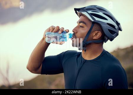 Uomo fitness, bicicletta e bottiglia di acqua potabile e indossare elmetto di sicurezza all'aperto in natura durante l'estate. Atleta maschile, esercizio fisico e equitazione idratazione Foto Stock