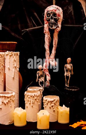 Scheletro con sangue e candele composizione Halloween su sfondo nero Foto Stock