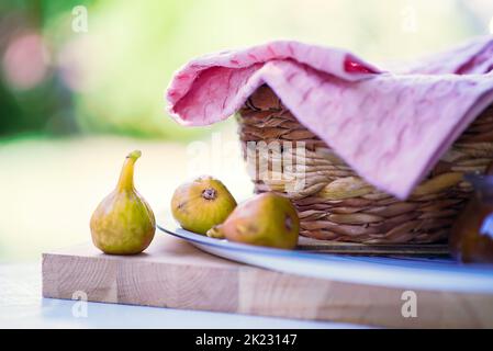 Fichi dolci maturi. Fichi mediterranei sani e fichi a fette su sfondo rustico in legno, la natura Foto Stock