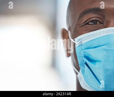 Uomo nero dottore con maschera viso covid ritratto per l'assicurazione sanitaria africana. Triste, paura e rischio negli occhi di un operatore medico con attrezzatura di sicurezza Foto Stock