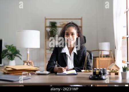 Ritratto sorridente avvocato donna seduto sul posto di lavoro in ufficio Foto Stock