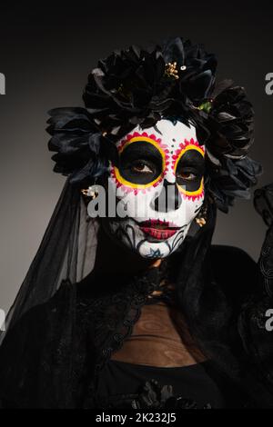 Donna in catrina trucco e corona con velo scuro su sfondo nero, immagine stock Foto Stock