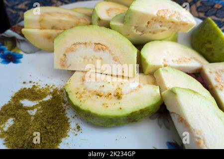 Un primo piano di insalata di guava servita con spezie indiane mescolate sale verde su un piatto bianco. India Foto Stock