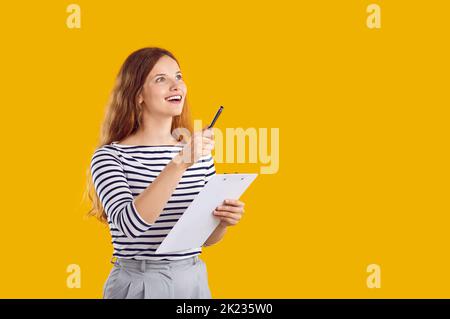 Felice eccitante giovane donna con la penna e la clipboard in mano che ha un'idea eccellente. Foto Stock