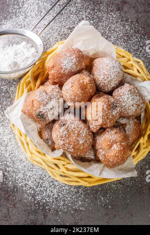 Le palle di olio Oliebollen olandesi sono anche talvolta chiamate ciambelle olandesi o palle di pasta olandesi closeup nel cestello sul tavolo. Vista dall'alto verticale da abov Foto Stock