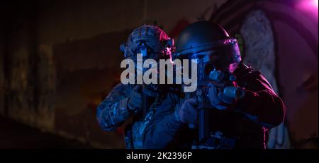 I soldati di guerra moderni al buio con munizioni da combattimento e armi nelle mani di laser-vista attrezzati sono in ordine di battaglia. Supporti misti. Foto Stock