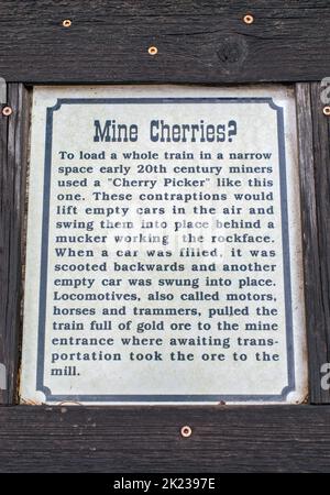 Cartello informativo a macchina chiamata Cherry Picker, per caricare il minerale d'oro per auto vuote, Miners Park a Bullion City, Canyon of Gold, Bullion Canyon, Tushar Mountains, Fishlake National Forest, Vicino a Marysvale, Utah, Stati Uniti Foto Stock