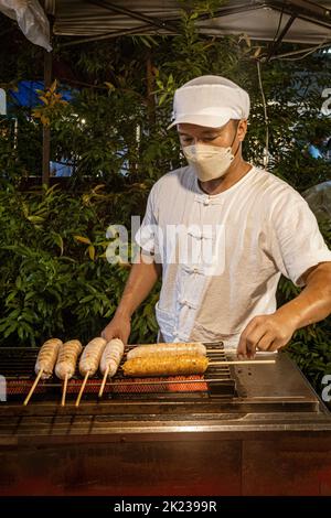 Chiang mai, Thailandia, 31 luglio 2022 - uomo venditore prepara salsicce hot dog da vendere ai tourinsts. Foto Stock
