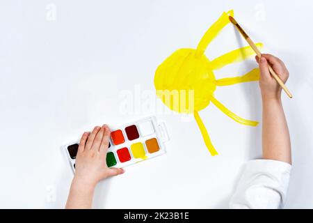 Le mani dei bambini disegnano il colore dell'acqua del sole. Creatività dei bambini, pittura, sviluppo iniziale. Luogo per un'iscrizione. Foto Stock