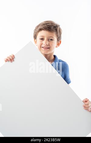 Sorridente ragazzo caucasico che mostra un poster pubblicitario bianco con spazio per il testo, su sfondo bianco. Foto Stock