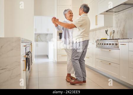 Coppia anziana danza, cucina e l'amore anziani di persone che trascorrono il tempo di qualità insieme a casa. Felice pensionamento di una donna e di un uomo dal Messico Foto Stock