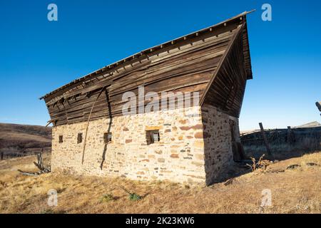 Fienile che è molto vecchio e che cade a parte vicino a una città fantasma Foto Stock