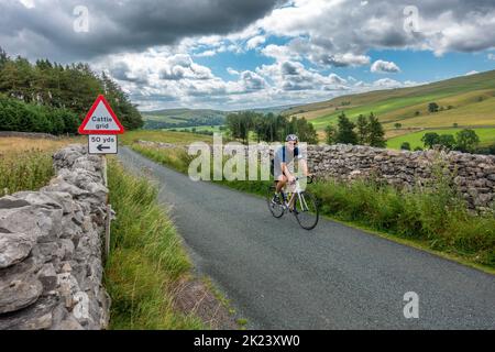 Guarda Littondale verso Wharfedale con un ciclista in una delle location del film per la nuova serie All Creatures Great and Small, Kilnsey Foto Stock