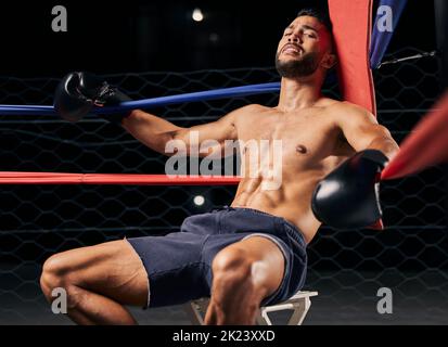 Fitness, pugile e uomo stanco nell'angolo ring out esausto di una partita di boxe sportiva in palestra o arena. Maschio attivo nel club di lotta, affaticamento e. Foto Stock