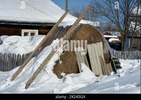 Pagliaio sotto la neve nel villaggio. Foto di alta qualità Foto Stock