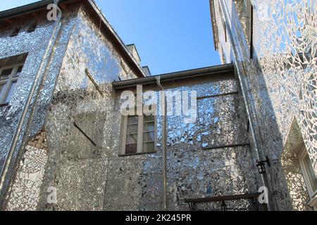 Edificio con pareti a specchio. Facciata di edificio in frammenti di specchio. Pareti di casa coperta da pezzi di specchio. Edificio con pareti in mi Foto Stock