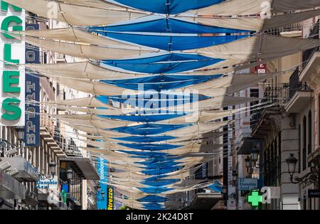 Una foto delle colorate coperture del sole che decorano una strada a Madrid. Foto Stock