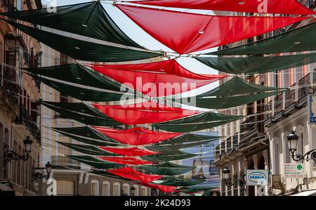 Una foto delle colorate coperture del sole che decorano una strada a Madrid. Foto Stock