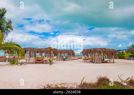 Panorama paesaggio vista sulla splendida isola di Holbox sabbia e spiaggia con capanne palapa e lettini e cielo blu in Quintana Roo Messico. Foto Stock