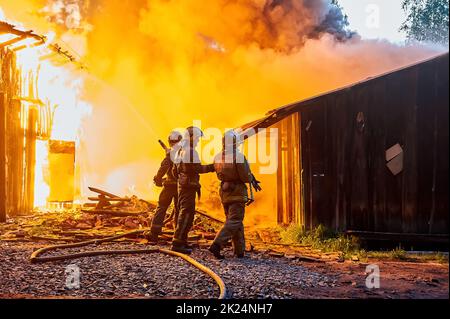 I vigili del fuoco spengono un incendio in un edificio agricolo. Foto di alta qualità Foto Stock