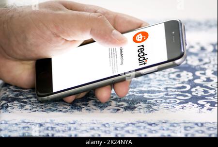 Roma, Italia, gennaio 2022: Tenere uno smartphone con l'app mobile Reddit sullo schermo. Reddit è un'aggregazione di notizie sociali e di conferenza americana Foto Stock