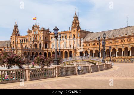 Siviglia, Andalusia, Spagna - 12 agosto 2021: Edificio rinascimentale centrale in piazza Plaza de Espana, vista sul fiume Guadalquivir con barche e gente Foto Stock