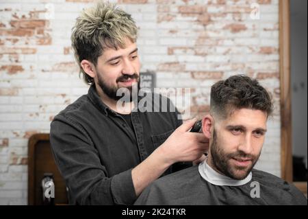 Primo piano di uomo felice ottenere un taglio di capelli, in parrucchiere. Foto di alta qualità. Foto Stock