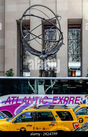 Statua dell'Atlante al Rockefeller Center con autobus Atlantic Express e taxi gialli di fronte, da vicino, New York City durante la giornata invernale, verticale Foto Stock