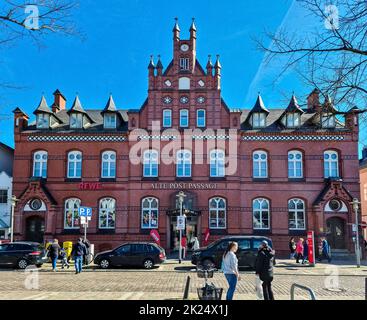 Neumuenster, Germania - 16. Aprile 2022: L'edificio storico del vecchio ufficio postale con un supermercato Rewe a Neumuenster, Germania Foto Stock