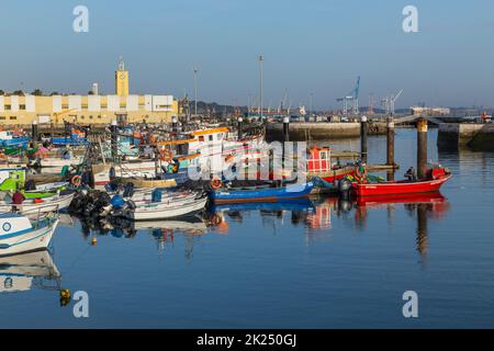 Sesimbra, Portogallo - 13 marzo 2022: Vista sul porto e sul villaggio di Sesimbra in Portogallo con variopinte barche da pesca Foto Stock