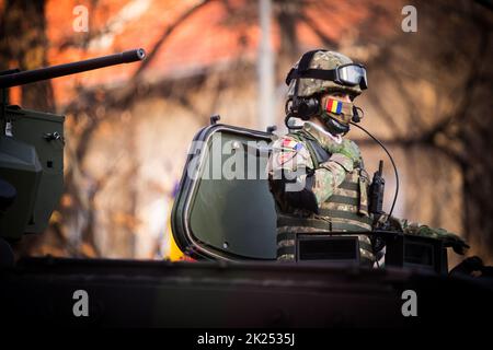 Bucarest, Romania - 1 dicembre 2021: Un soldato rimane sul tetto di un corazzatore di personale, durante una parata militare a Bucarest, Romania. Foto Stock