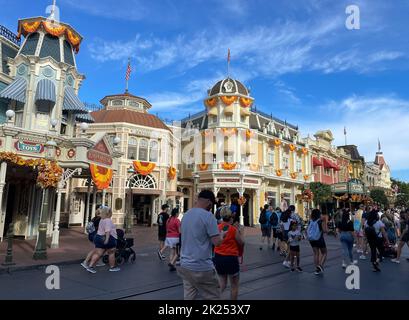 Bay Lake, FL USA - 14 settembre 2022: Vista su strada dei turisti che camminano lungo la strada principale USA al parco magico regno con design autunnale Foto Stock