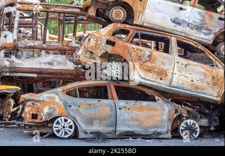 Una visione di auto bruciate dopo gli attacchi dei razzi da parte dell'esercito russo. Guerra della Russia contro l'Ucraina. Veicolo civile dopo l'incendio. Cimitero delle automobili i Foto Stock