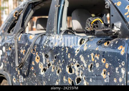 Auto piena di proiettili. Guerra della Russia contro l'Ucraina. Un'auto di civili sparata dall'esercito russo durante l'evacuazione di donne e bambini. Foto Stock