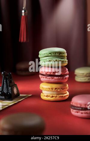 Pila di amaretti colorati dai sapori diversi - pistacchio, lampone, limone. Pubblicità creativa per prodotti macaron in stile retrò. Francese bis Foto Stock