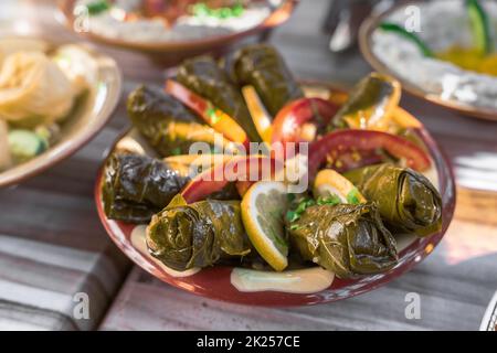 Piatto tradizionale di cucina mediorientale. Antipasto di carne e riso avvolto in foglie d'uva. Gusto raffinato ed elegante delle foglie d'uva. Libanese Foto Stock
