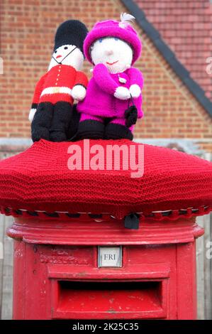 Un cappello in lana lavorato a mano, dai colori stravaganti, decora una tradizionale scatola di colonne rosse, celebrando il Giubileo del platino della Regina Elisabetta II 2022, REGNO UNITO. Foto Stock