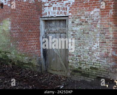 Particolare di una vecchia parete intemperiata con porta Foto Stock