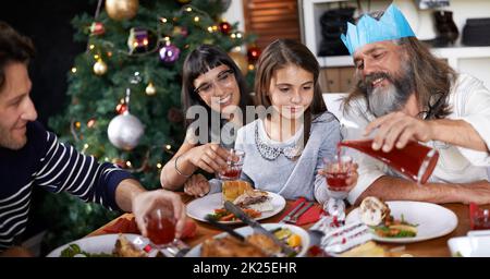 Grazie a mia bella nipote, che versa il succo della nipote a chrismas. Foto Stock