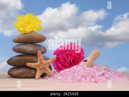 Sapone e pietre da massaggio con conchiglie di mare su sfondo cielo blu Foto Stock