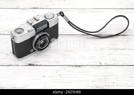 vecchia telecamera su sfondo bianco in legno Foto Stock