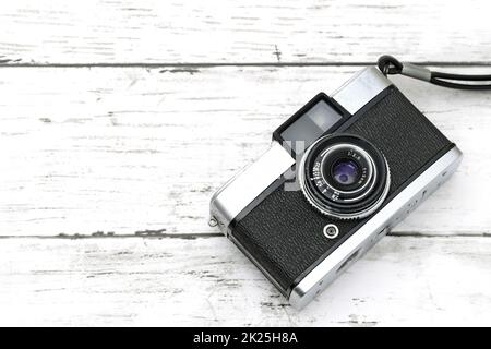 vecchia telecamera su sfondo bianco in legno Foto Stock