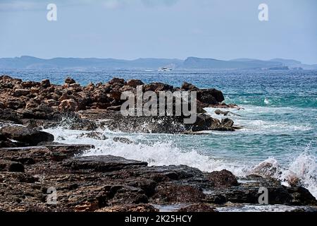 Rocce sulla riva colpite dall'onda Foto Stock